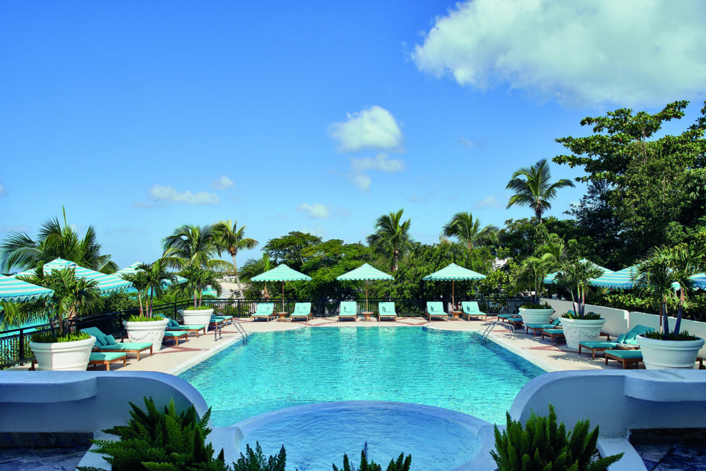 The main pool at La Samanna in St Martin with teal and white lounge furniture.